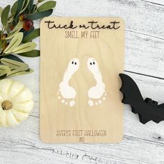 a wooden plaque with two ghost feet on it