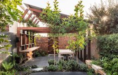 an outdoor garden with trees and plants in the sun shining on the building's roof