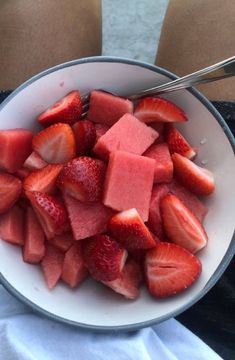 a white bowl filled with sliced up strawberries