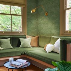 a living room with green couches and pillows