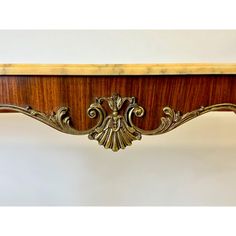 an ornately carved wooden shelf with brass accents