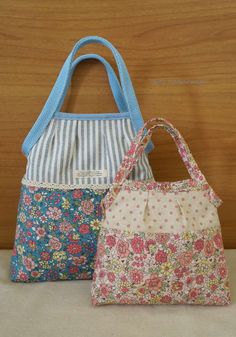 two purses sitting next to each other on a table