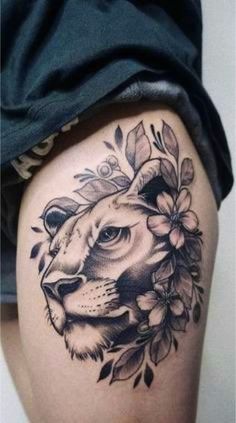 a woman's thigh with a lion and flowers tattoo on her leg, showing the side