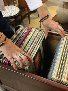 two hands reaching for records in a drawer