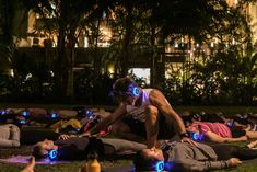 a group of people laying on the ground with their faces lit up in blue lights