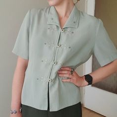 Pretty mint green vintage button down blouse with delicate embroidery details in great condition. Material assumingly chiffon blend, fabric is non crinkly, very light and slightly see through. Will fit S-L,  Measurements laid flat : Bust 50 cm / 19" Waist 45 cm / 17" Sleeve lenght 27 cm /10" Total lenght 60 cm / 23"  My height is 1.70 m/ 5"7 Elegant Green Spring Shirt, Elegant Green Shirt For Spring, Collared Shirt With Buttons For Spring, Elegant Green Summer Shirt, Spring Formal Shirt With Collared Neckline, Fitted Spring Blouse With Buttons, Fitted Button Blouse For Spring, Short Sleeve Embroidered Shirt For Work, Fitted Formal Shirt With Floral Embroidery