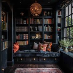 a living room filled with lots of bookshelves next to a couch and window