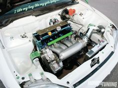 the engine compartment of a white car with its hood up and it's hood open