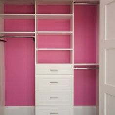 an empty closet with pink walls and white drawers