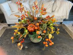 a vase filled with lots of different types of flowers and fruits on top of a table