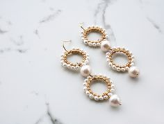 A modern take on pearls while also keeping it traditional. I've mixed small and large pearls for a unique look. These statement earrings will be a showstopper on your wedding day. + Freshwater Pearls. 14K Gold Fill Ear Wire. 14K Gold Plate Circles. + Length: 2.75 inches. + Earrings take 1 business day to make. + Your jewelry will come in a jewelry box, tied with a ribbon. ➤➤ Have a question about this product, reach out to me here ➙ https://www.etsy.com/conversations/new?with_id=9057464&refe White Pearl Pendant Earrings For Celebration, Akoya Pearl Drop Bridal Earrings For Wedding, Handmade Elegant Pearl Earrings For Celebration, Pearl Drop Akoya Pearl Earrings For Wedding, Pearl Chain Earrings For Celebration, Akoya Pearl Drop Earrings For Wedding, Pearl Earrings For Celebration, White Akoya Pearl Earrings For Wedding, Round Pearl Pendant Earrings For Wedding