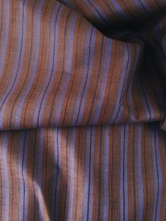 an orange and purple striped fabric with some black stripes on it's side, in close up