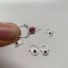 These are soooooo pretty. Made is 925 sterling silver with tribal details, set with a deep red garnet stone. The rings are all 1cm (.40”) in diameter. The wire is 20 gauge.Stones shine light through them since the back is open. Hard to see this when they are lying flat.One of the images contains numbers to specify which you would like from the drop down menu. Spiritual Red Ruby Ring In Sterling Silver, Unique Sterling Silver Body Jewelry Gift, Unique Sterling Silver Body Jewelry For Gifts, Spiritual Sterling Silver Ruby Ring, Spiritual Silver Body Jewelry For Gift, Pierced Sterling Silver Body Jewelry As Gift, Sterling Silver Pierced Body Jewelry As Gift, Sterling Silver Body Jewelry, Sterling Silver Body Jewelry As Gift