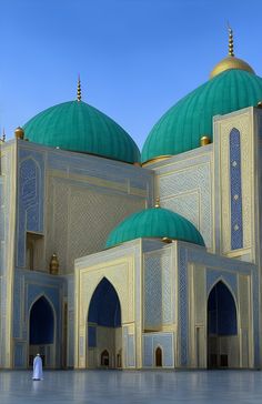 two large green and white buildings with blue domes