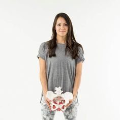 a woman is holding two teddy bears in her hands and smiling at the camera while standing against a white background