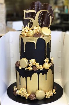 a three tiered cake with chocolate and popcorn on top