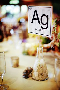 a table with a sign that says ag silver on it and an image of pine cones in a beakle