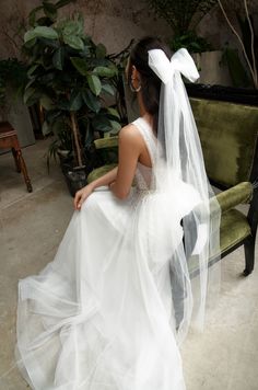 a woman in a wedding dress sitting on a couch with her back to the camera