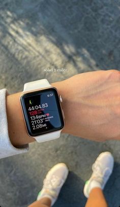 a person wearing a white wrist watch with an apple watch face on their arm and the time displayed