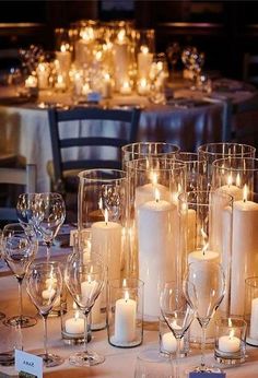 a table topped with lots of white candles