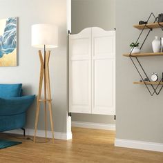 a living room filled with furniture and a blue chair next to a wall mounted book shelf