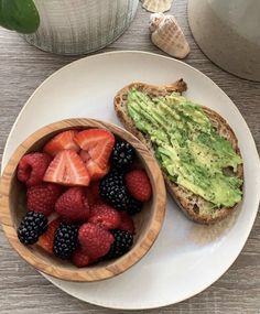 an avocado toast with berries and strawberries in a bowl