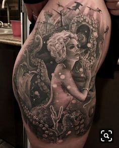 a woman's thigh with an octopus and mermaid tattoo on the side, under her belly