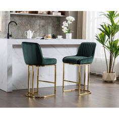 two black and gold bar stools in front of a marble counter with flowers on it