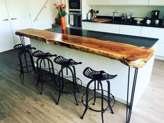 a kitchen island made out of wood and metal barstools