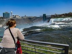 a woman is looking at the falls in niagara