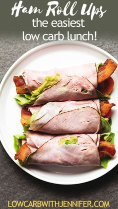 ham roll ups on a white plate with lettuce and bacon in the middle