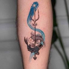 a tattoo on the leg of a man with an arrow and fish in it's tail