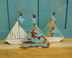 three wooden sailboats are sitting on a table