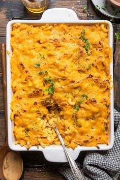 a casserole dish filled with macaroni and cheese, garnished with parsley