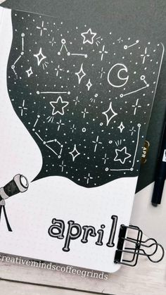 a black and white notebook with an image of a telescope in the sky on it