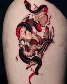 a man with a snake and skull tattoo on his thigh