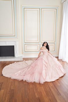 a woman in a pink dress is sitting on the floor with her arms behind her back