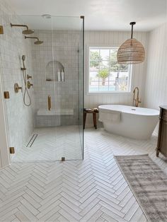 a white bathroom with herring tile flooring and a large bathtub in the corner