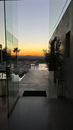 the sun is setting behind some glass walls