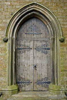 an old wooden door with iron work on it