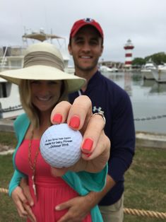 a man and woman holding up a golf ball