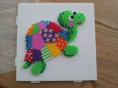 this is a cross stitch picture of a teddy bear in the shape of a turtle