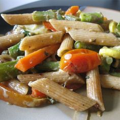 a white plate topped with pasta and veggies