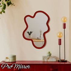 a mirror sitting on top of a wooden dresser next to a plant and potted plant