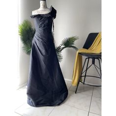 a dress on display in a room with a chair and potted plant behind it