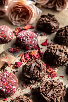 chocolate truffles with sprinkles and rose petals on the table next to them