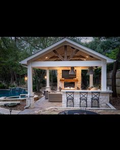 an outdoor kitchen and grill area in a backyard