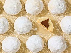 there are many snowball cookies on the table and one has a piece of chocolate in it