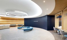 an empty conference room with blue chairs and tables in the center, along with a circular light fixture