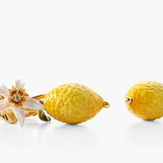 two yellow lemons with flowers on them sitting next to each other